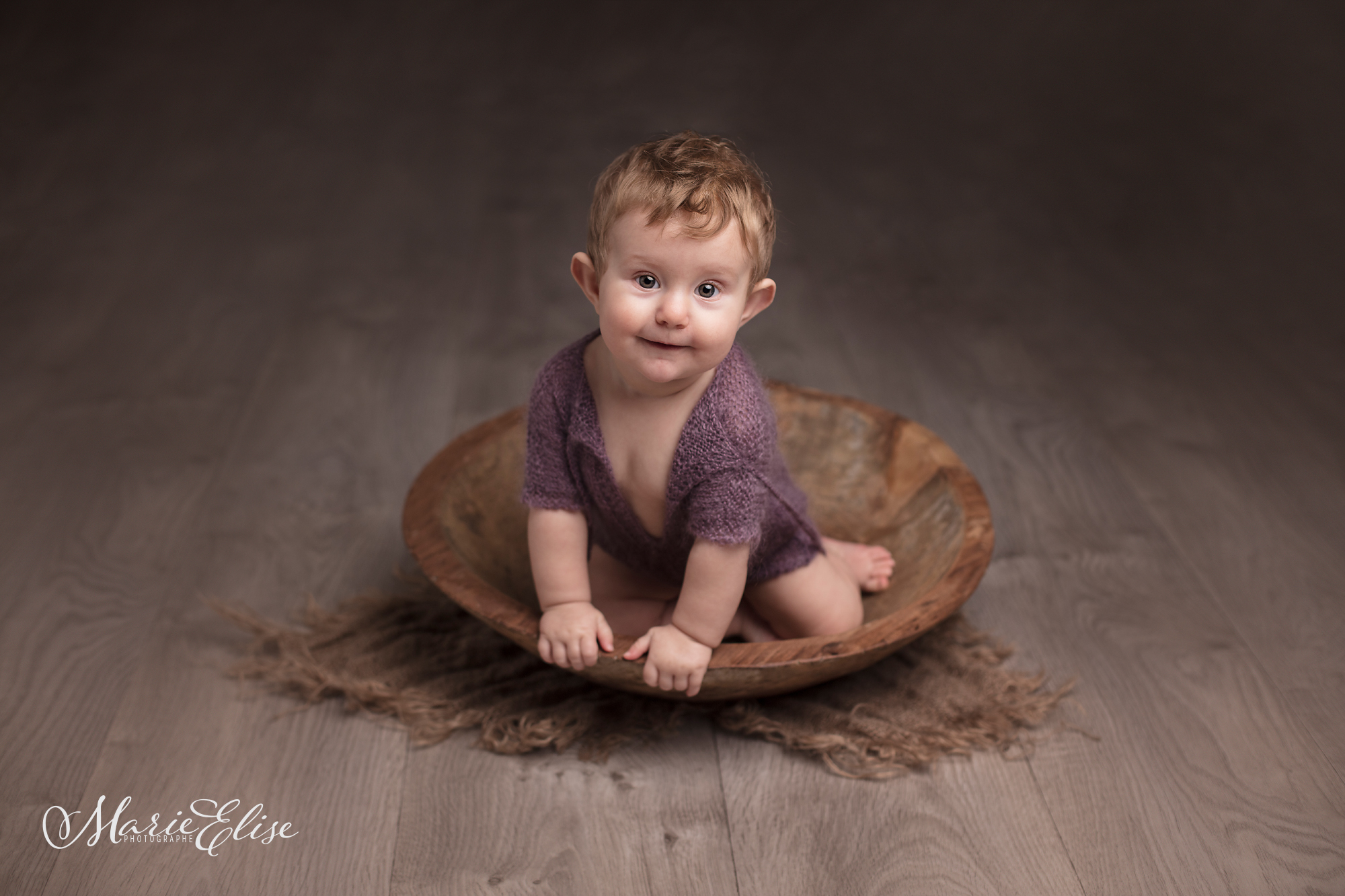 Bébé assis dans un bol en bois